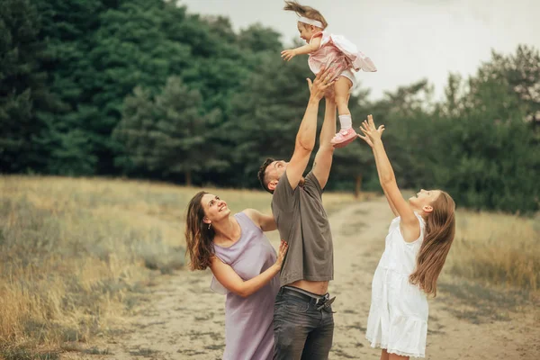 Familia feliz se divierte en un paseo y vomita a su hija . — Foto de Stock