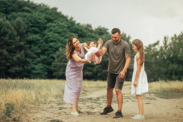 Glückliche Familie mit zwei Kindern hat Spaß und lacht beim Spaziergang. — Stockfoto