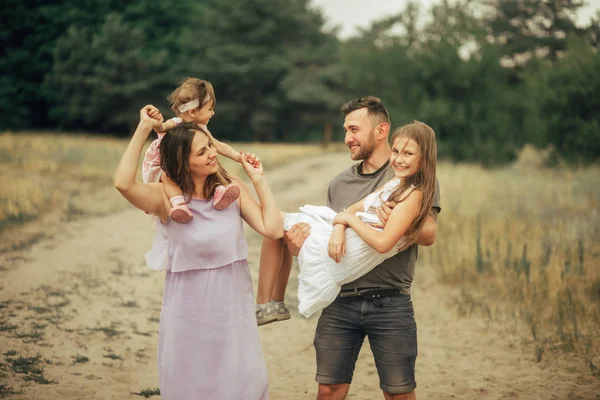 Glückliche Familie mit zwei Kindern hat Spaß und lacht beim Spaziergang. — Stockfoto