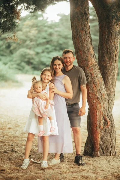 Familie steht neben Kiefer im Wald. — Stockfoto