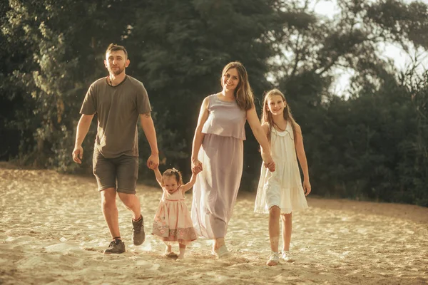 Eine glückliche Familie spaziert durch den Wald. — Stockfoto