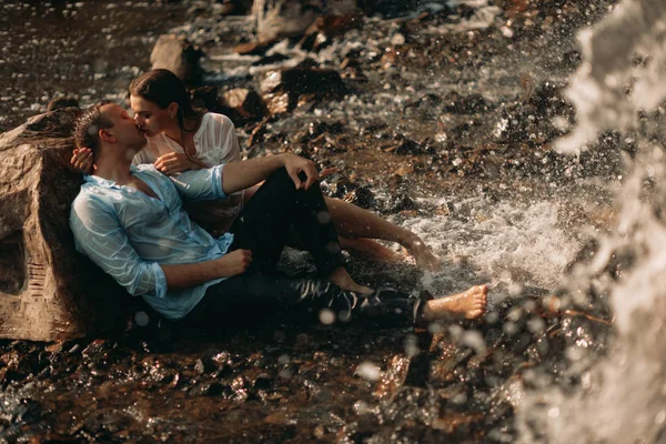 Par kyssar bredvid vattenfallet. — Stockfoto