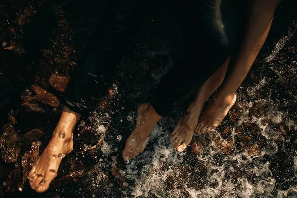 Wet legs of couple in love in the water.