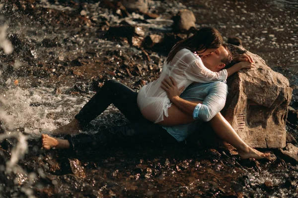 Un couple qui fait l'amour près du rocher dans une côte . — Photo