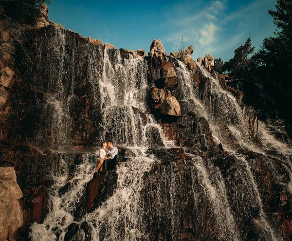 滝と空を背景に抱きしめるカップル. — ストック写真