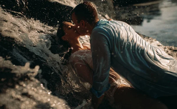 Un couple pendant l'amour à côté d'une cascade . — Photo