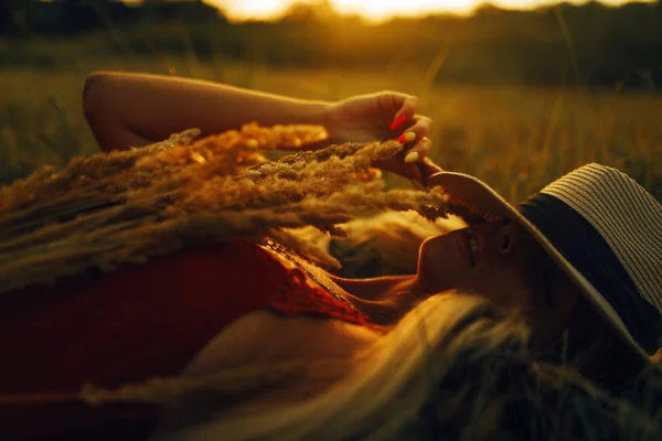 Jeune femme couchée sur la prairie au coucher du soleil . — Photo