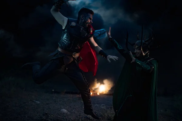Cosplayers portray battle of goddess Hela and superhero Thor.