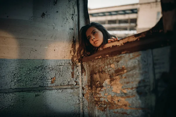 Woman looks out window of abandoned ship. — Stock Photo, Image