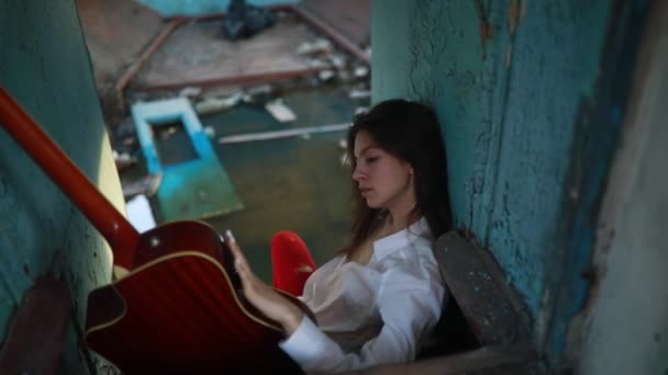 Młoda Smutna Kobieta Siedzi Gitarą Wewnątrz Starego Opuszczonego Statku Białej — Wideo stockowe