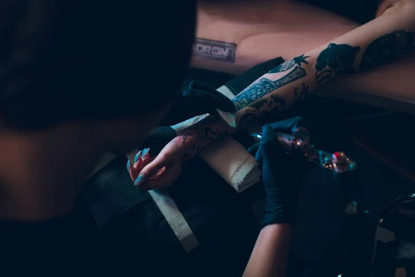 Καλλιτέχνης τατουάζ δημιουργεί ένα τατουάζ στο χέρι ενός κοριτσιού. — Φωτογραφία Αρχείου