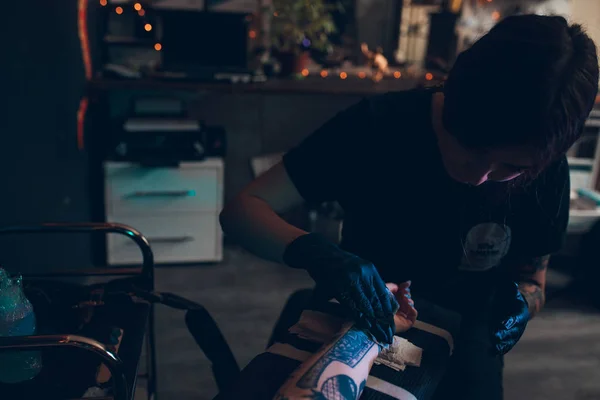 Татуировщик создает татуировку на руке девушки . — стоковое фото