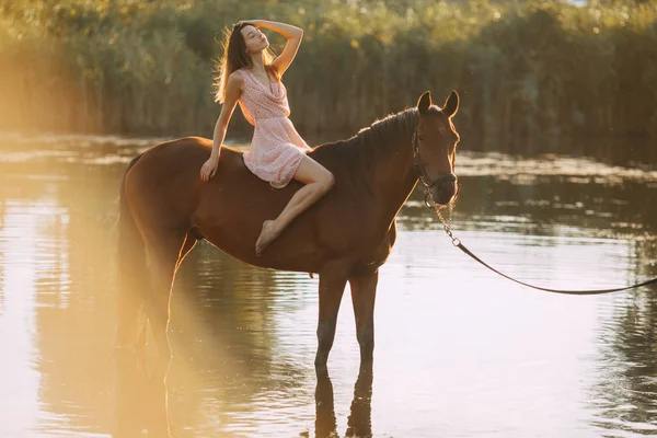 女性は川で馬に乗って座る. — ストック写真