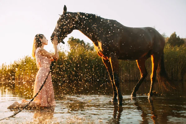 Woman is next to the horse against background of the water splas — Stock Photo, Image