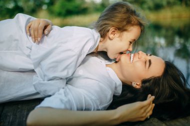 Anne ve kızı oynamak ve ri yakınlarındaki ahşap bir köprüde eğlenin