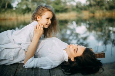 Anne ve kızı yalan ve rive yakınlarındaki ahşap köprü üzerinde istirahat