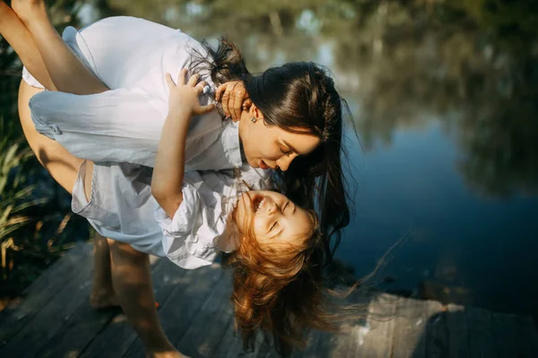 Mutter und Tochter spielen und haben Spaß in der Nähe eines kleinen Flusses. — Stockfoto