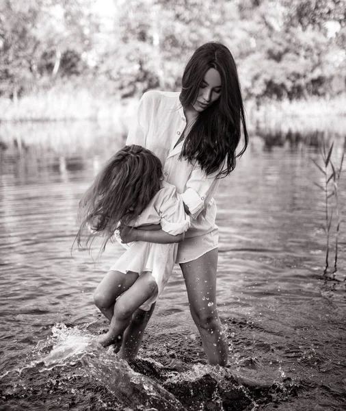 Mor och dotter leka och ha kul i vattnet på en flod. — Stockfoto