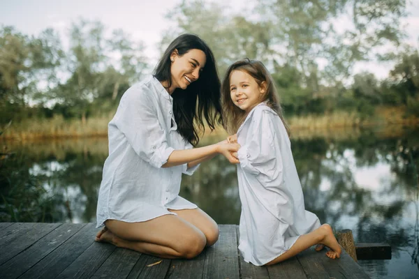 Anne ve kızı oynamak ve küçük bir nehir yakınında eğlenmek. — Stok fotoğraf