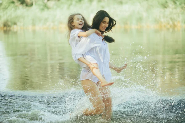 Mor och dotter springa och ha kul i vattnet med många SPLA — Stockfoto