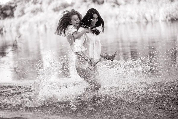 Mãe e filha correr e se divertir na água com muitos spla — Fotografia de Stock