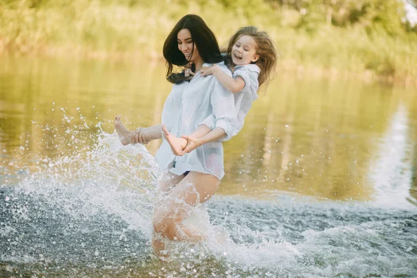 Mor och dotter springa och ha kul i vattnet med många SPLA — Stockfoto