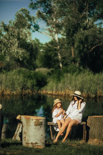 Mère et fille assis sur le banc à côté de souches sur backgroun — Photo