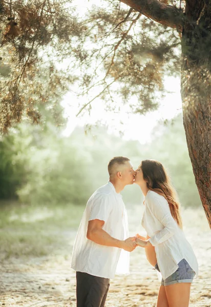 Mulher grávida está se beijando com seu marido na floresta . — Fotografia de Stock