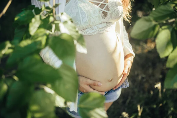 Closeup of pregnant woman belly at forest. — Stock Photo, Image