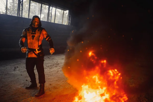 Homem retratando guerreiro Escorpião com correntes poses no fogo backgr — Fotografia de Stock