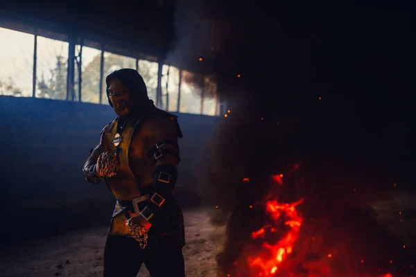Manusia menggambarkan prajurit Scorpion dengan rantai pose di api backgr — Stok Foto