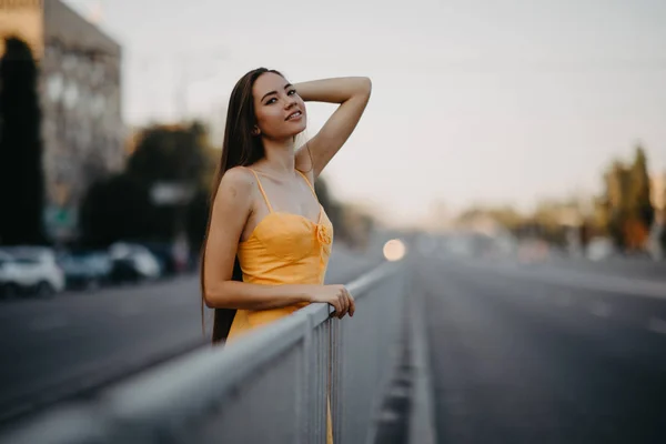 Eine junge Frau steht vor einem Hintergrund des Stadtbildes. — Stockfoto