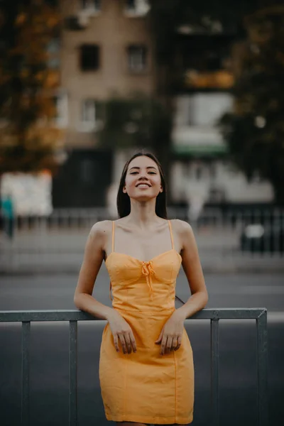 Una giovane donna si erge su uno sfondo di paesaggio urbano . — Foto Stock