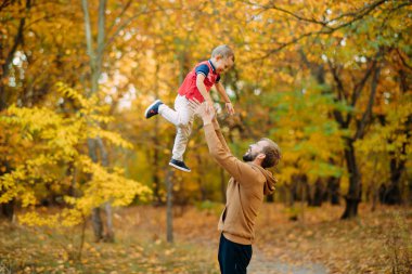 Baba oğlunu sonbahar ormanında yürürken fırlatır..
