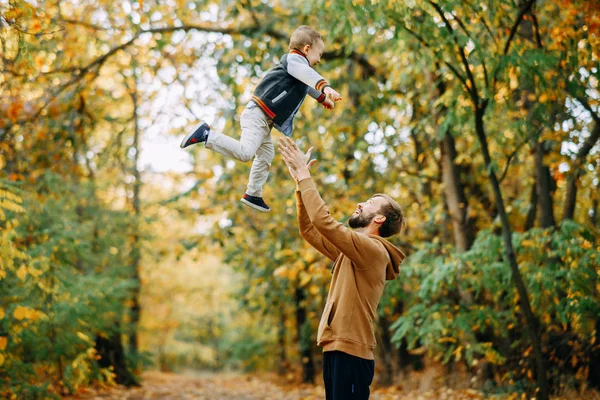Padre vomita a su hijo mientras camina en el bosque de otoño . —  Fotos de Stock
