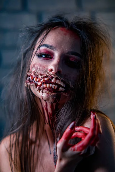 Woman in a carnival costume of bloody mutant stands with a lot of ugly teeth. — Stock Photo, Image