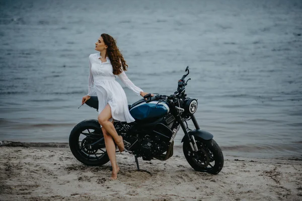 Jovem Mulher Fica Praia Vestido Branco Perto Moto Contra Fundo — Fotografia de Stock