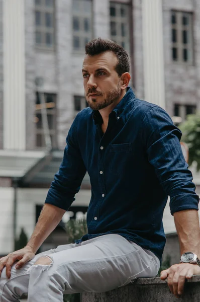 Junger Mann Sitzt Und Grübelt Auf Bank Vor Hintergrund Modernen — Stockfoto