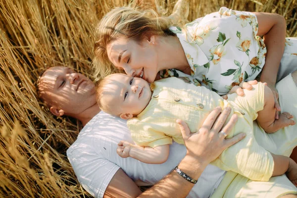 Šťastná Mladá Rodina Dítětem Ležícím Odpočívajícím Žlutém Pšeničném Poli Closeup — Stock fotografie