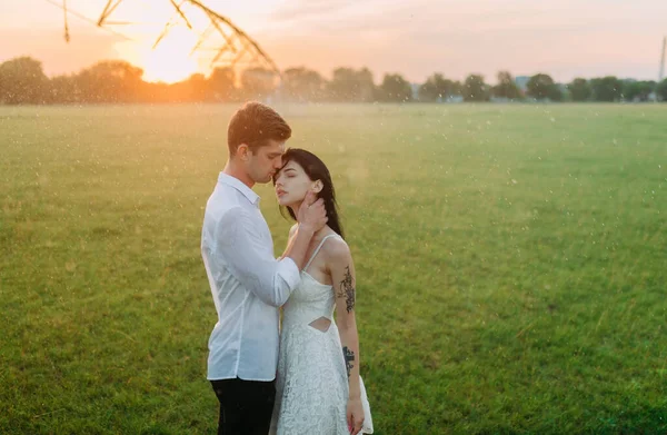 Pareja Enamorada Para Abraza Entre Césped Bajo Gotas Agua Del —  Fotos de Stock