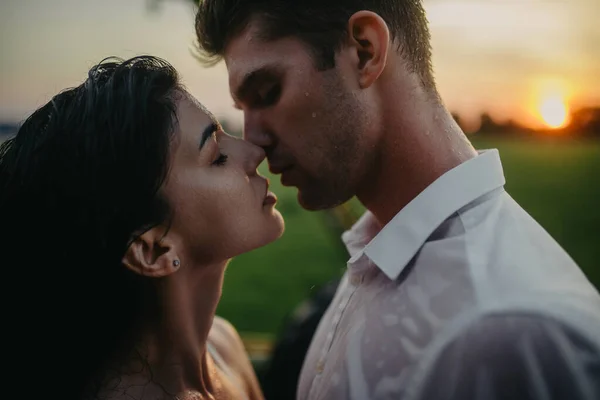 Verliebtes Paar Küsst Und Umarmt Sich Bei Sonnenuntergang Unter Regentropfen — Stockfoto