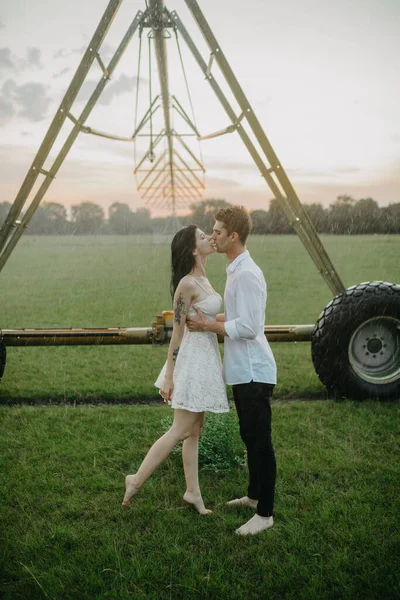 愛のキスで二人組と抱擁下水滴から農業噴霧器で日没 — ストック写真