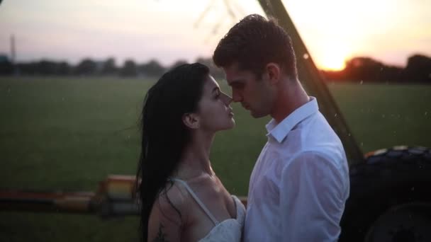 Szerelmesek Ölelkeznek Csókolóznak Vízcseppek Alatt Mezőgazdasági Permetezőből Naplementekor Közelkép — Stock videók