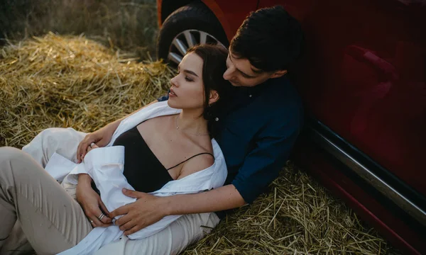 Jovem Casal Apaixonado Repousa Palheiro Perto Carro Vermelho Prado — Fotografia de Stock