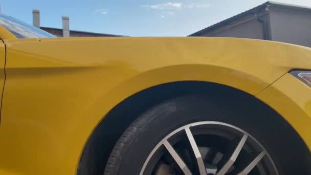 Zicht Zijkant Van Een Gele Sportwagen Tegen Achtergrond Van Bakstenen — Stockvideo