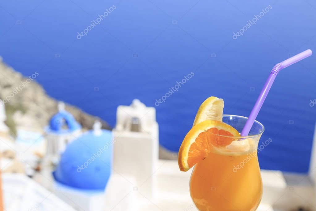 Orange Lemon juice with famous blue church of oia background in Oia, Santorini, Greece