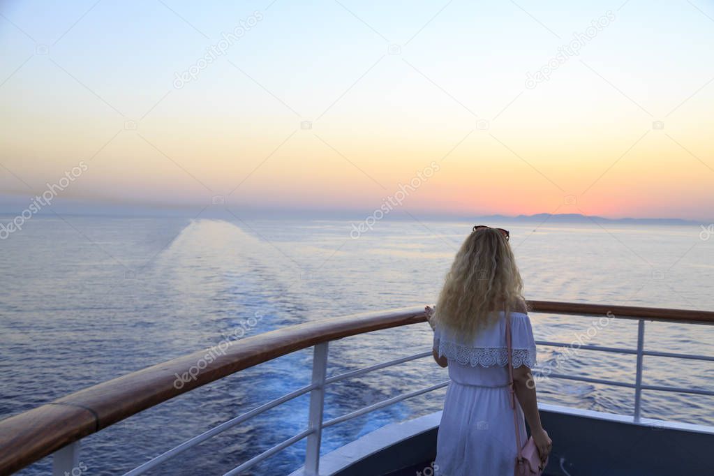 Blonde watching sunset from cruise ship