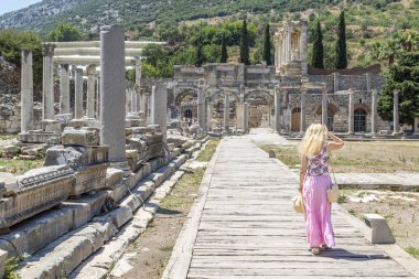 Sarışın kadın Untere Agora'da Efes, Izmir, Türkiye içinde Celsus Kütüphanesi için yürüyüş