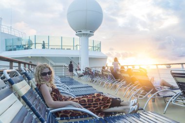 Philipsburg, St Martin - 1 Aralık 2016:, günbatımı sırasında şezlong cruise gemi içinde yatan sarışın kadın.
