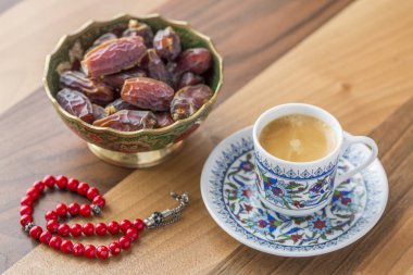 Turkish coffee, dates, and red rosary on table side view
